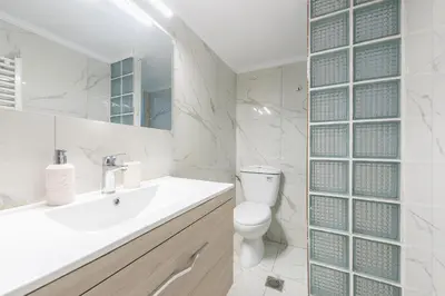 a white bathroom with a toilet and a sink at Victoria Queens Suites Apartments in Athens