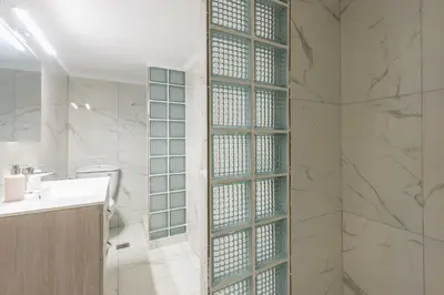 a bathroom with a shower with a glass partition at Victoria Queens Suites Apartments in Athens