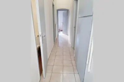 a hallway with a white refrigerator and a tile floor at A Great Stay at a Comfortable Large Apartment in Athens