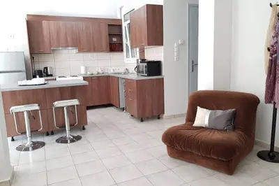 a kitchen with a brown chair and a kitchen counter at A Great Stay at a Comfortable Large Apartment in Athens