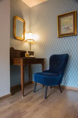 a blue chair sitting next to a desk with a mirror at Vol.3 in Athens