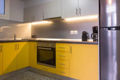 a kitchen with yellow cabinets and a refrigerator at Vol.3 in Athens