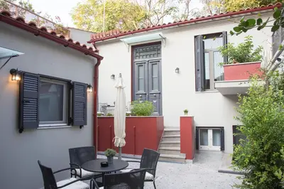 a patio with a table and chairs in front of a house at Vol.3 in Athens