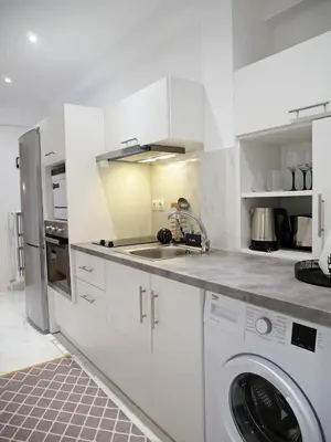 a white kitchen with a sink and a dishwasher at Acropolis View Penthouse in Athens