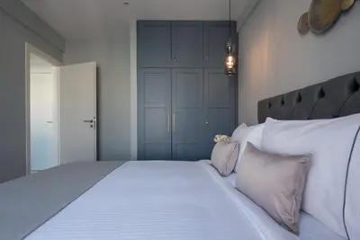 a bedroom with a large bed with white sheets and pillows at Acropolis View Penthouse in Athens
