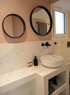 a bathroom with a sink and two mirrors on the wall at Acropolis View Penthouse in Athens