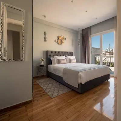 a bedroom with a large bed and a large window at Acropolis View Penthouse in Athens