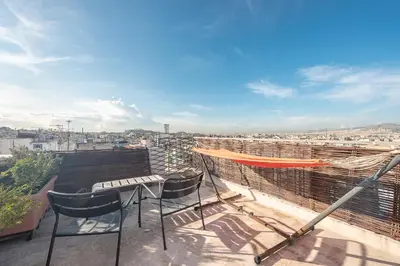 a balcony with a table and chairs on a roof at Amazing Acropolis View from Exarcheia in Athens