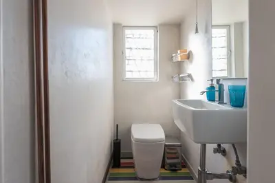 a bathroom with a white toilet and a sink at Amazing Acropolis View from Exarcheia in Athens