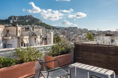 a balcony with chairs and a view of a city at Amazing Acropolis View from Exarcheia in Athens