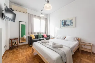 a bedroom with a large bed and a couch at Amazing Acropolis View from Exarcheia in Athens