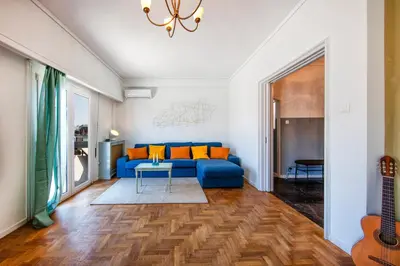 a living room with a blue couch and a table at Amazing Penthouse in Athens city center in Athens