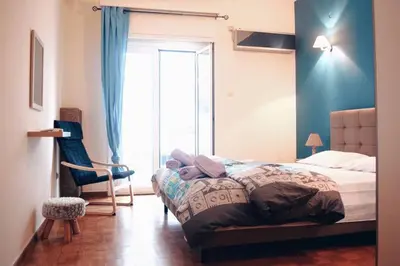 a bedroom with a bed and a chair and a window at Athens Central 2BD Apartment at Acropolis Plaka in Athens