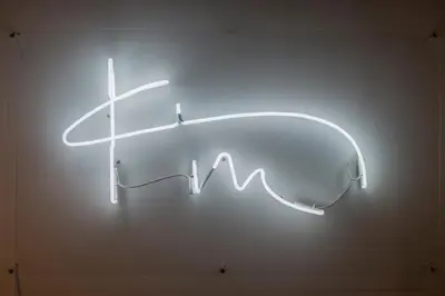 a neon sign on a wall with a heartbeat at Kin Athens in Athens