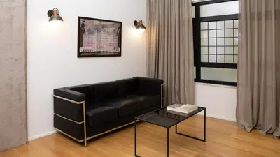 a living room with a black couch and a table at Kin Athens in Athens