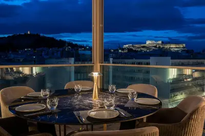 a table with chairs and a view of the city at Heritage Hill Hotel in Athens