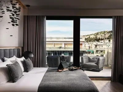 a bedroom with a large bed and a large window at Heritage Hill Hotel in Athens