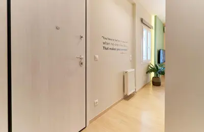 a hallway with white walls and a door with writing on it at “Olympic Spirit” Apt in N. Kosmos neighbourhood in Athens