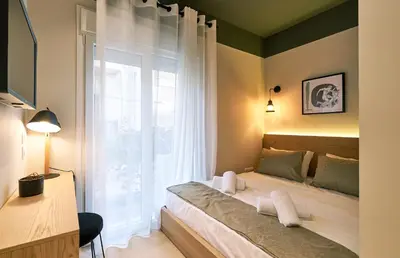 a bedroom with a bed and a large window at “Olympic Spirit” Apt in N. Kosmos neighbourhood in Athens