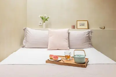 a tray with a drink and fruit on a bed at Anafiotika hideaway acropolis Athens by Cycladica in Athens