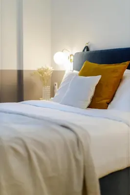 a white bed with yellow pillows and a blue headboard at Divine 1BR Apartment near the Acropolis museum in Athens