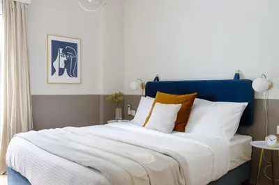 a bedroom with a large bed with a blue headboard at Divine 1BR Apartment near the Acropolis museum in Athens