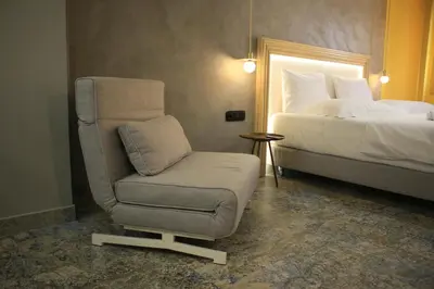 a bedroom with a chair and a bed at La mouette apartment,Plaka, Athens in Athens