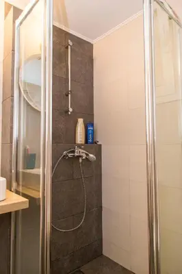 a shower with a glass door in a bathroom at Gazi District Next To Subway 2 in Athens