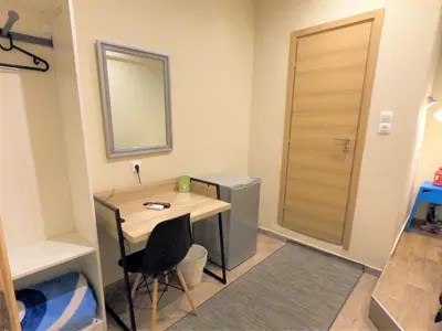 a small room with a desk and a mirror at Achillion Hotel Piraeus in Piraeus