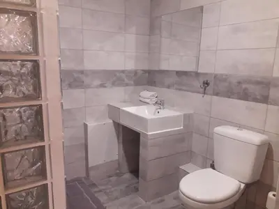 a bathroom with a white toilet and a sink at Achillion Hotel Piraeus in Piraeus