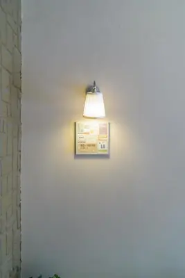 a light on a wall with a sign on it at Achillion Hotel Piraeus in Piraeus