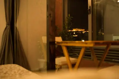 a wooden table in a room with a window at Mosaics aprtm in Parliament square with Acropolis View in Athens