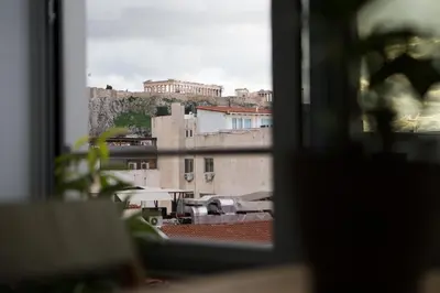 a view of a city from a window at Mosaics aprtm in Parliament square with Acropolis View in Athens