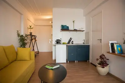 a living room with a couch and a table and a kitchen at Mosaics aprtm in Parliament square with Acropolis View in Athens