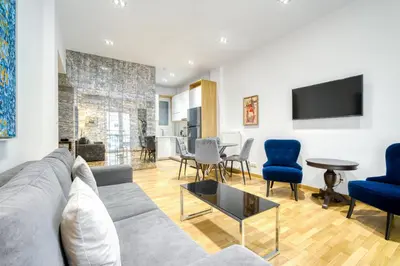 a living room with a gray couch and blue chairs at Stylish, Sunny New 2 Bedroom, Prime Central Athens in Athens
