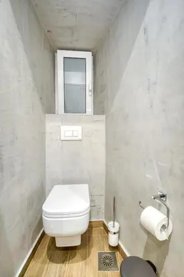 a bathroom with a white toilet and a window at Stylish, Sunny New 2 Bedroom, Prime Central Athens in Athens