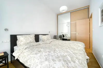 a bedroom with a large bed with a white comforter at Stylish, Sunny New 2 Bedroom, Prime Central Athens in Athens