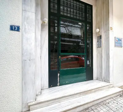 a green door of a building with a red car inside at Stylish, Sunny New 2 Bedroom, Prime Central Athens in Athens