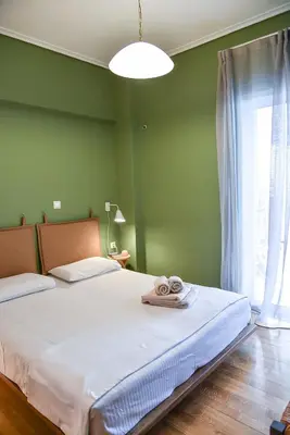 a green bedroom with a bed with towels on it at Homie Apartment next to Acropolis in Athens