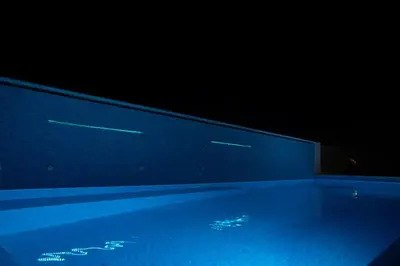 a blue swimming pool in a dark room at Luxury heated pool Villa in Lagonissi