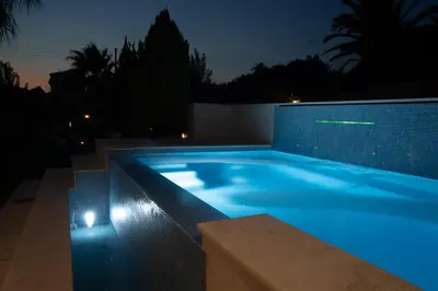 a large swimming pool with blue lighting in a house at Luxury heated pool Villa in Lagonissi