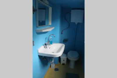 a blue bathroom with a sink and a toilet at Vravrona Sea View Country House near Athens in Vravrona