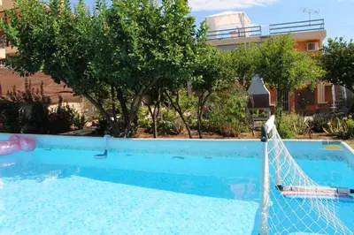 a pool with a net in front of a house at Vravrona Sea View Country House near Athens in Vravrona