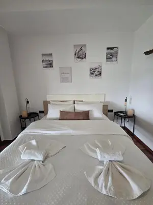 a large white bed with two white towels on it at A10 SecretHouse in Athens
