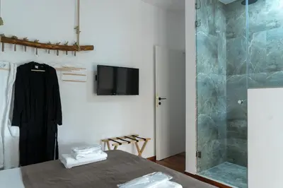a room with a bed and a tv and a shower at A10 SecretHouse in Athens