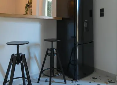 a kitchen with two bar stools and a refrigerator at A10 SecretHouse in Athens
