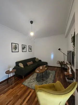 a living room with a green couch and a table at A10 SecretHouse in Athens