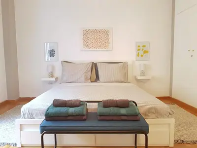 a bedroom with a large bed with two pillows on it at Colourful Apartment in the heart of Athens in Athens