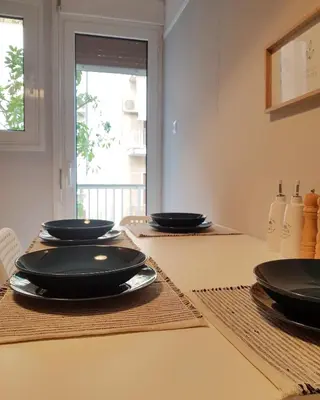 a table with black plates on top of it at Colourful Apartment in the heart of Athens in Athens