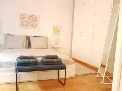 a bedroom with a bed and a table with pillows on it at Colourful Apartment in the heart of Athens in Athens